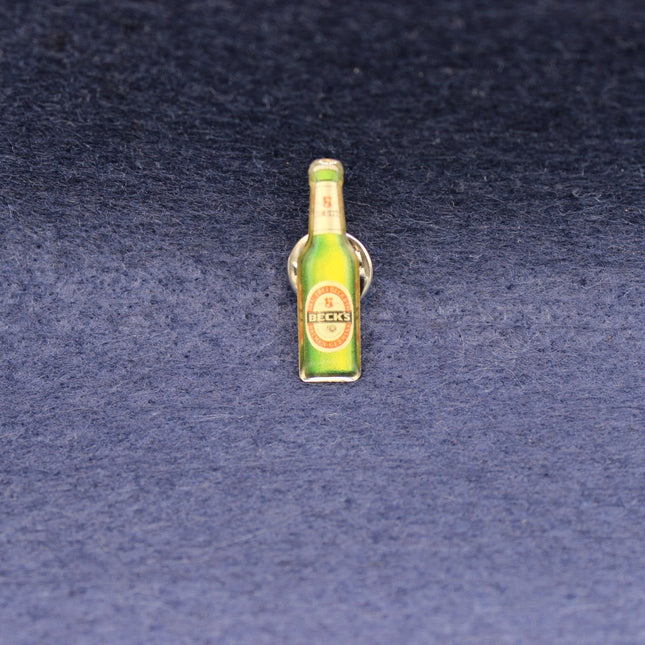 Vintage Becks Bottle pin badge on a blue background