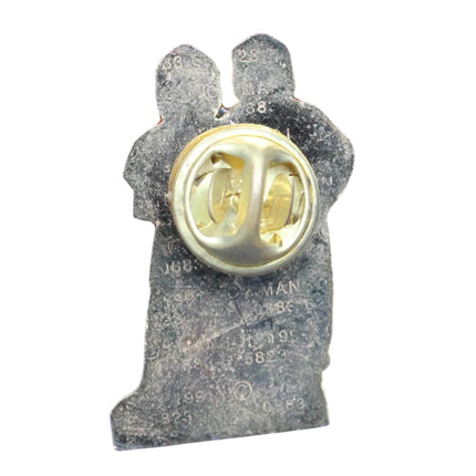 Pin with a gold center and gray silhouette on a blue textured background