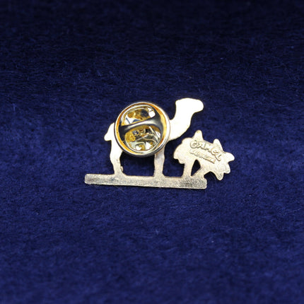Vintage Camel Cigarettes pin with gold camel and palm trees design.