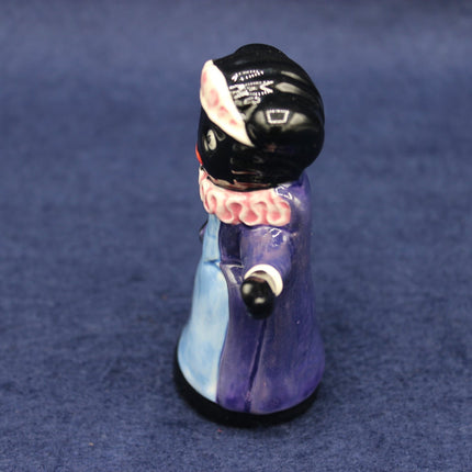 Small figurine of a Golly Queen on a  blue textured background