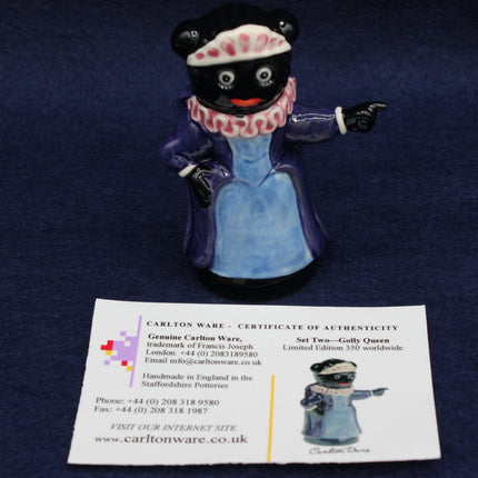 Carleton Ware Golly figurine of a Queen in a blue dress with a certificate of authenticity on a dark blue background