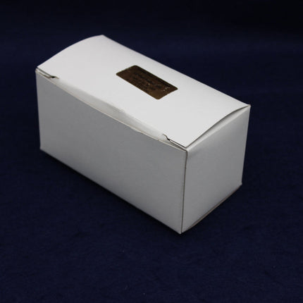 White rectangular box with a gold emblem on a dark blue background