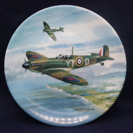 Decorative plate with a painting of two World War II-era fighter planes flying over a landscape.