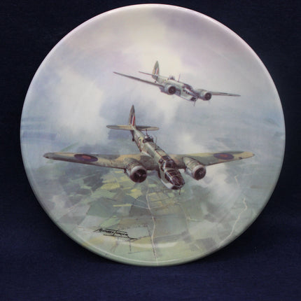 Decorative plate with artwork of two airplanes flying over a landscape.