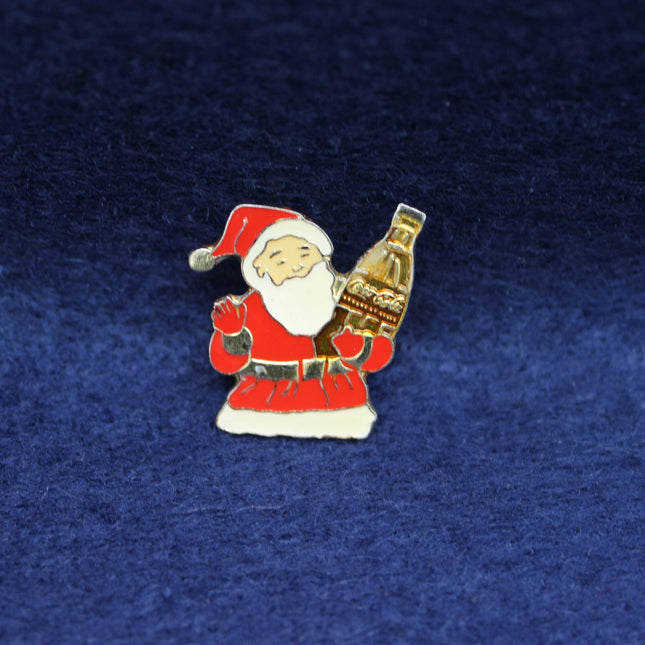 Pin with Santa Claus holding a Coca-Cola bottle on a blue background