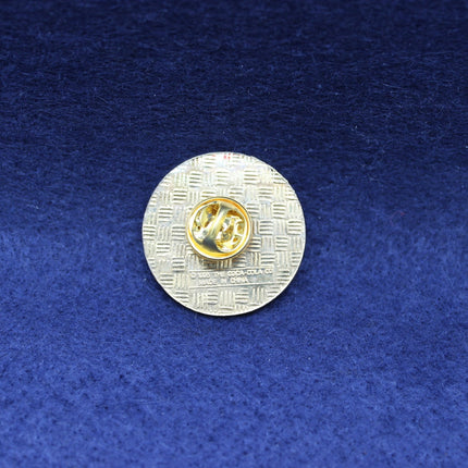 Silver and gold Coca Cola badge on a blue textured background