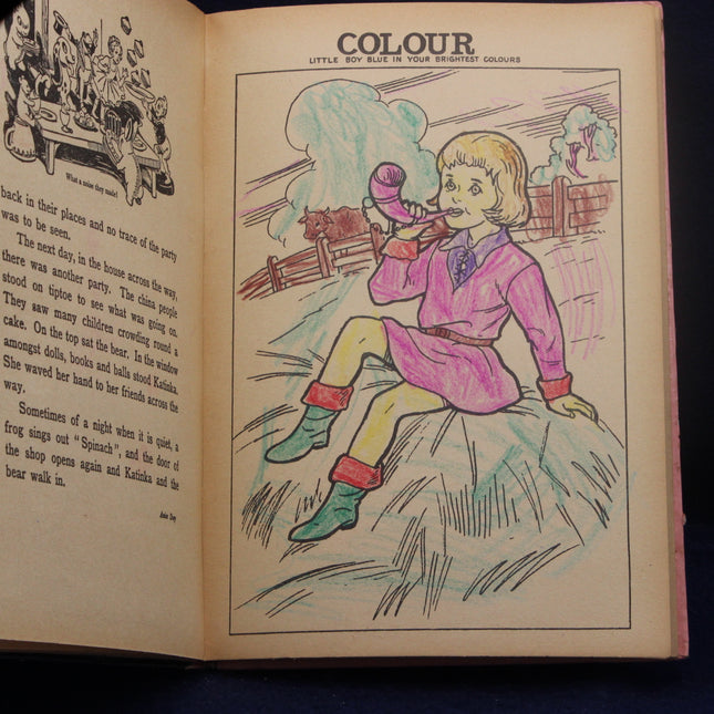 Open book with a colored illustration of a girl playing a horn, titled 'COLOUR'.
