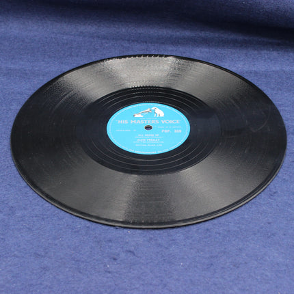Black shellac Elvis Presley record with a blue label on a blue fabric background