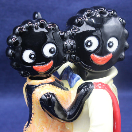 Vintage-style figurine with black hair, white eyes, and red lips on a blue background