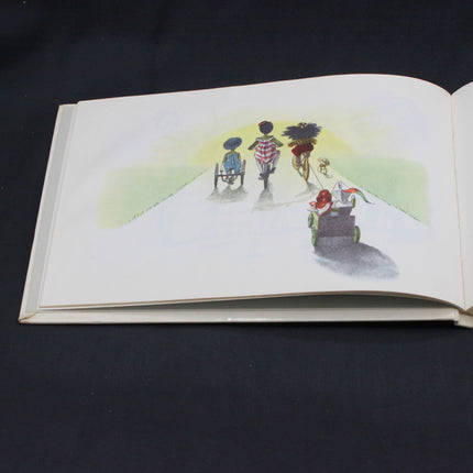 Open book with a colorful illustration of children on a path with a Golliwog