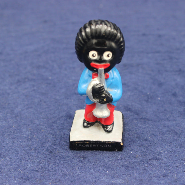 Figurine of a character with a black topknot, blue shirt, and red pants on a blue background.