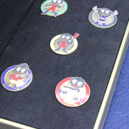 Set of five golly olympic games limited edition badges on a dark blue background