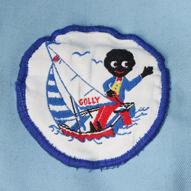 Embroidered patch of a character on a sailboat with 'Golly' text on a light blue background