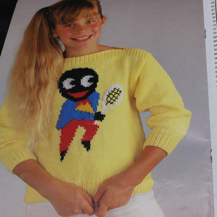Person wearing a yellow sweater with a Golly character design on a plain background