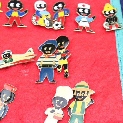 A close-up of several colorful Robertson's Golly enamel pin badges in different roles, arranged on a bright red Golly badge collectors scroll.