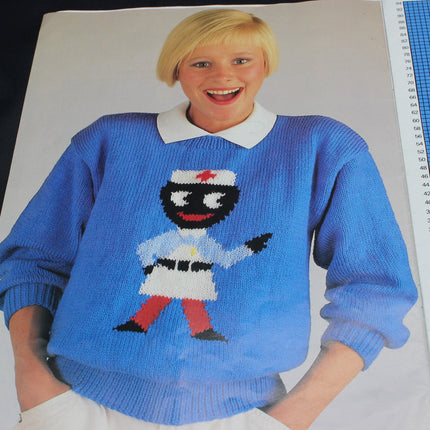 Person wearing a blue sweater with a Golly Nurse design, standing next to a ruler.