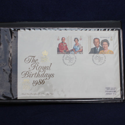 A collectible first-day postage envelope commemorating 'The Royal Birthdays 1986' from Jersey, sealed in a clear protective plastic sleeve and displayed against a dark navy background.