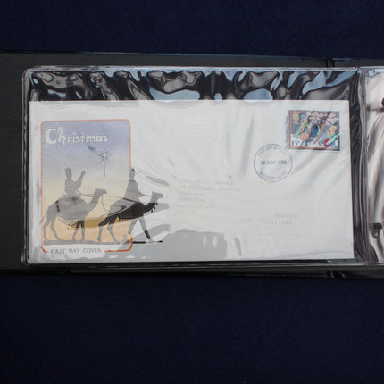 A collectible Christmas-themed postmark envelope from New Zealand, sealed in a protective plastic sleeve and displayed inside a black plastic case against a dark blue background.