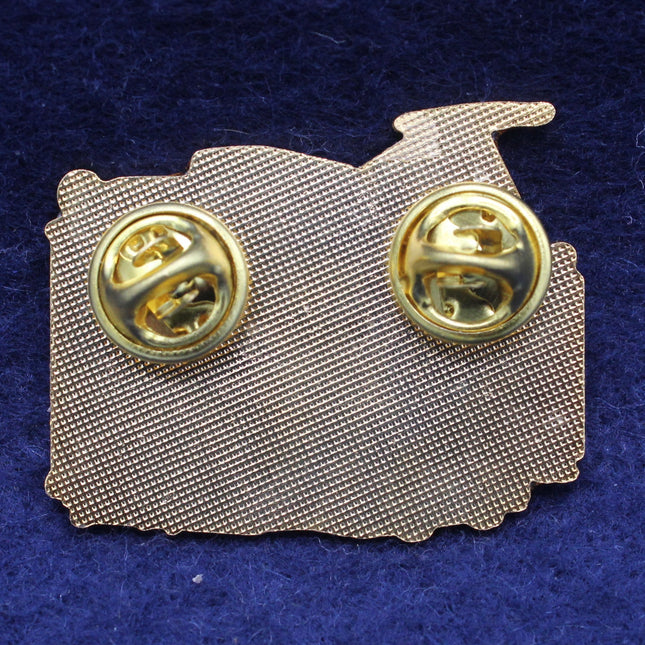 Gold brooch with mesh back on a blue background
