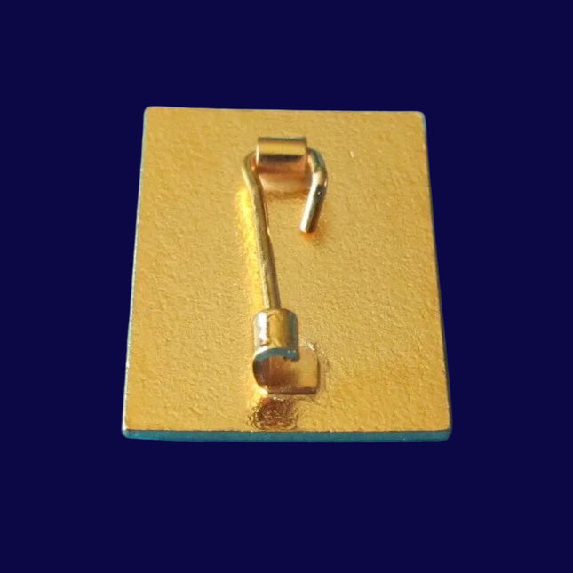 Gold-colored metal clip on a blue background