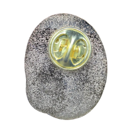 Metallic badge with a yellow center on a blue textured background