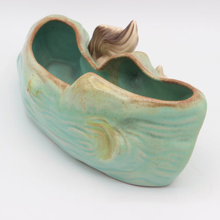 A ceramic fish-shaped planter or decorative pot with a glossy light green glaze, brown rim, and a sculpted fish tail detail on top, shown on a white background.