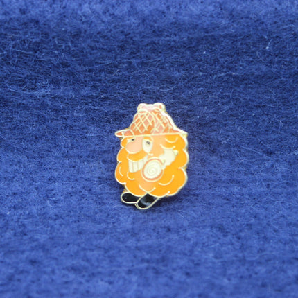 Pin with a character wearing a hat on a blue fabric background