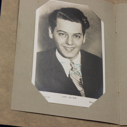 Vintage black and white photo of Les Allen in a suit with a name tag on a brown background