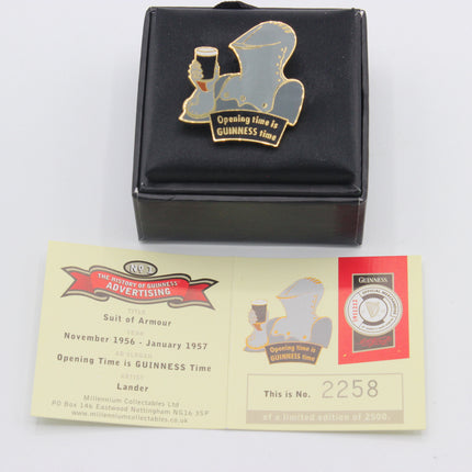 A Guinness-themed enamel pin with a gold and silver silhouette of a man holding a pint, mounted on a black square backing card. Below the card is a cream-colored collectible paper insert with printed text and a small red Guinness logo, photographed on a white background.
