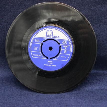 Black vinyl record with blue label on a dark blue background