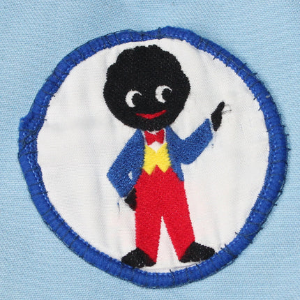 Embroidered patch of a Pointing Golly with a blue outline on a light blue background