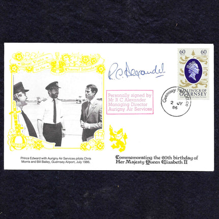 A commemorative envelope or postcard-style printed item from Guernsey, dated 1988, featuring a black-and-white photo of three men at an airport, yellow decorative border elements, a blue Queen Elizabeth II portrait stamp, and printed commemorative text. The item is photographed against a dark textured background.
