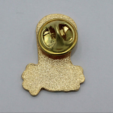 A small gold-colored enamel Guinness pin with a textured glitter finish and a round gold metal clasp, shown on a plain light gray background.