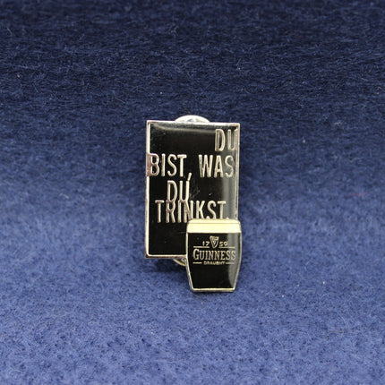 Guinness beer mug badge with text on a blue textured background