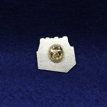 Coca Cola Pin badge with gold center and white base on a blue textured background
