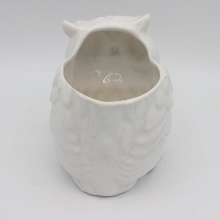 A white ceramic owl-shaped planter with a textured feather pattern and an open top, shown against a plain light gray background.